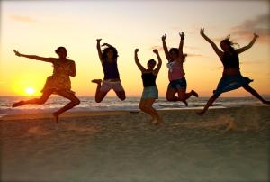 a group of girls jumping on the beach at sunset at Casa Losodeli & Coworking- Adults Only in Puerto Escondido