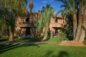 ein Gebäude mit Palmen davor in der Unterkunft Villa Al Assala Palmeraie in Marrakesch