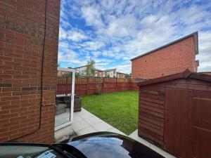 a view of a backyard with a fence and a building at 3BR-Sleeps 6 -Walk to Etihad & AO Arena in Manchester