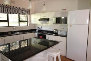 a kitchen with white appliances and a black counter top at Seagull Road 838 in Margate
