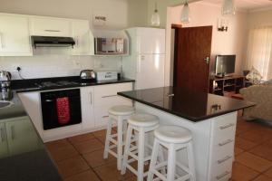 a kitchen with white cabinets and a black counter top at Seagull Road 838 in Margate