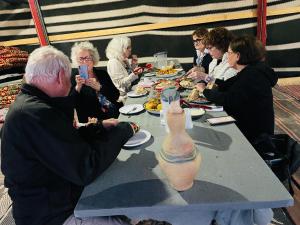 a group of people sitting around a table with a vase at חאן נחל חווה Han Nahal Hava in Mitzpe Ramon