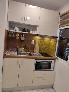 a small kitchen with white cabinets and a sink at Desafinado in Burgas City +7 photos