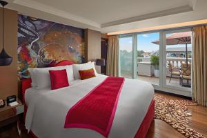 河内Hotel de l'Opera Hanoi - MGallery的带阳台的酒店客房内的一张大床
