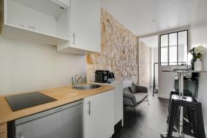 a kitchen with a sink and a counter top at CMG Louis Blanc - Gare de l'Est in Paris