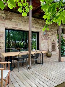 a patio with a table and chairs on a wooden deck at La Grange des Duc(s) in Eckbolsheim