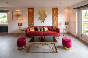 a living room with a red couch and pink stools at Gîte au coeur de l'Alsace Maison Gatsby in Staffelfelden