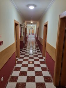 an empty hallway of an office building with a checkerboard floor at Zöldsziget Menedék, Rendezvény-és pihenőház in Bárna