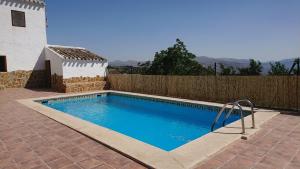 a swimming pool in front of a wooden fence at Gîte rural 100 % authentique (8 pers) avec piscine in Los Arenales
