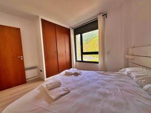 a bedroom with a large bed with two towels on it at Tucamp 2.6 justo al lado del telecabina in Encamp