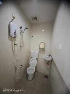a bathroom with a shower and a toilet and a sink at Melawati Ria Hotel in Kuala Selangor