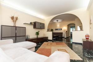 ein Wohnzimmer mit 2 weißen Sofas und einer Küche in der Unterkunft Oasi di pace a 10 min. dall'aeroporto in Genua