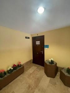 un vestíbulo con una puerta y flores en cajas en Hostal Milmarcos en Zaragoza
