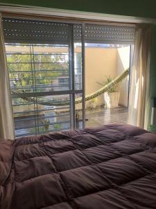 1 dormitorio con cama y ventana grande en Amplio y Luminoso Departamento en Saavedra en Buenos Aires