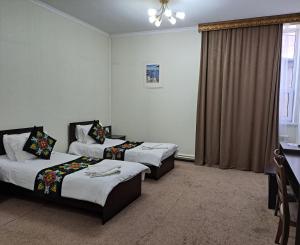 um quarto de hotel com duas camas e uma janela em Ocean hotel em Osh