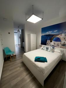 Un dormitorio con una cama grande con una toalla azul. en APARTAMENTOS MAPAMUNDI, en Badajoz