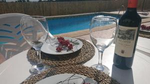 a table with two glasses and a bottle of wine at Gîte rural 100 % authentique (8 pers) avec piscine in Los Arenales