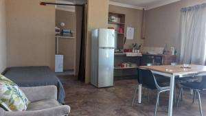a kitchen with a refrigerator and a table with chairs at 4BFarming Rest camp and Camping in Naris