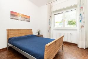 ein Schlafzimmer mit einem Bett und zwei Fenstern in der Unterkunft Oasi di pace a 10 min. dall'aeroporto in Genua