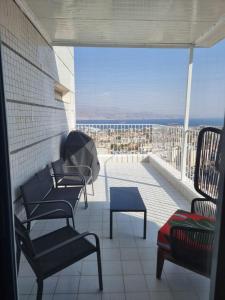 a balcony with chairs and a view of the ocean at דירת גג נוף המפרץ 1105-6 in Eilat
