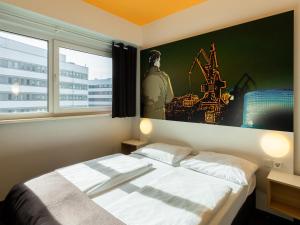 B&B Hotel Duisburg Hbf-Süd في دويسبورغ: غرفة نوم بسرير ودهان على الحائط
