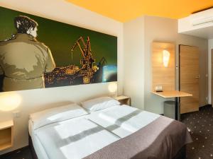 杜伊斯堡的住宿－B&B Hotel Duisburg Hbf-Süd，一间设有一张床的客房,墙上挂着一幅画