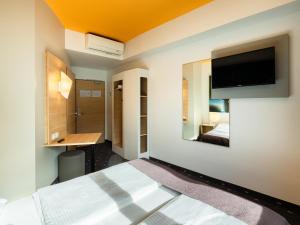 a hotel room with a bed and a tv on the wall at B&B Hotel Duisburg Hbf-Süd in Duisburg