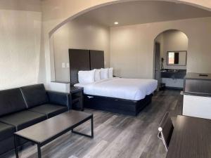 une chambre d'hôtel avec un lit et un canapé dans l'établissement Days Inn by Wyndham Dickinson TX, à Dickinson