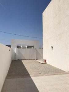 a large white building with a fence in front of it at Villa Houmet Souk in Houmt Souk