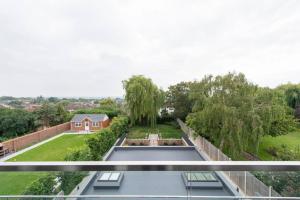 a view of a garden from the balcony of a house at Chigwell 1BR + Study Escape in Chigwell