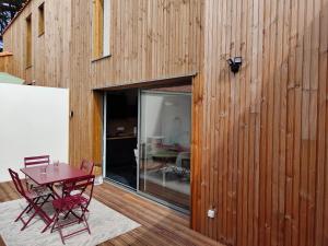 a wooden house with a table and chairs on a patio at Escapade aux dunes in Brétignolles-sur-Mer