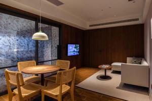 salon ze stołem, krzesłami i kanapą w obiekcie Kilin Hotel, JiaoXi w mieście Jiaoxi