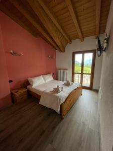 a bedroom with a large bed and a large window at Orobie Holiday Apartments in Albosaggia