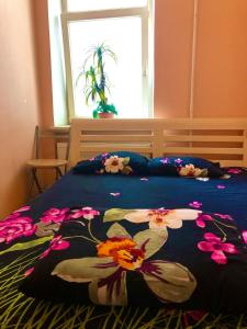 a bed with a blue blanket with flowers on it at BalticApart Riga in Riga