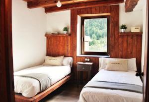 2 camas en una habitación con ventana en CAL SOLDAT en Os de Civís