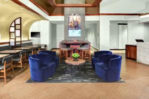 a lobby with blue chairs and a table and a bar at Hyatt Place Nashville Brentwood in Brentwood