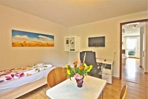 a room with a bed and a table with flowers on it at Ferienwohnung KAKADU Apartment Dresden Laubegast WLAN TV Fahrrad in Dresden