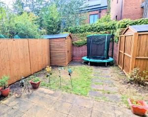 einen Garten mit einem Zaun und einer Bank und einigen Pflanzen in der Unterkunft 3 Bedroom house in Camberwell in London