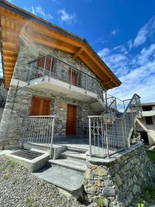 una casa de piedra con escaleras delante en Orobie Holiday Apartments en Albosaggia