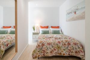 a bedroom with two beds and a mirror at Host Wise - Peaceful Sunny Flat - Ace Location in Porto