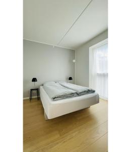 a white bed in a white room with a window at ApartmentInCopenhagen Apartment 1561 in Copenhagen