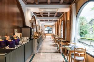 un ristorante con una fila di tavoli e sedie di Hotel Spa Termes Carlemany ad Andorra la Vella