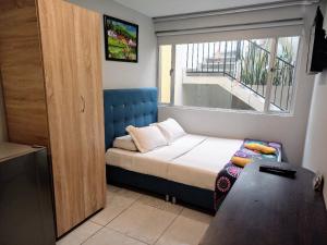 a small bedroom with a bed and a window at ApartaSuites Bogota Campin in Bogotá