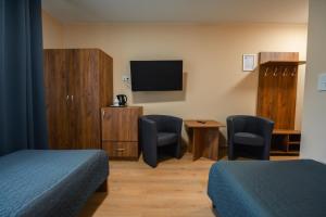 a room with two beds and a flat screen tv at Pokoje Gościnne MODR 