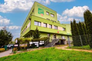 a green building with a sign on the side of it at Pokoje Gościnne MODR 