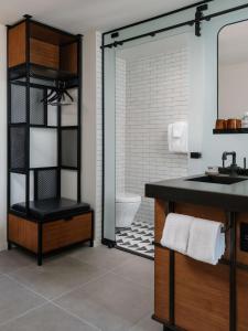 a bathroom with a sink and a toilet and a mirror at Tommie Austin, JDV by Hyatt in Austin