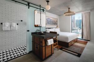 a bedroom with a bed and a desk and a bathroom at Tommie Austin, JDV by Hyatt in Austin