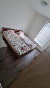 ein Schlafzimmer mit einem Bett in einem Zimmer mit einem Fenster in der Unterkunft Flower apartman in Dunajská Streda