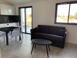 ein Wohnzimmer mit einem Sofa und einem Tisch in der Unterkunft Maison terrasse proche centre ville et ile de Ré in La Rochelle