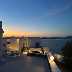 uma vista para uma villa com o oceano à noite em Santorini View em Acrotíri